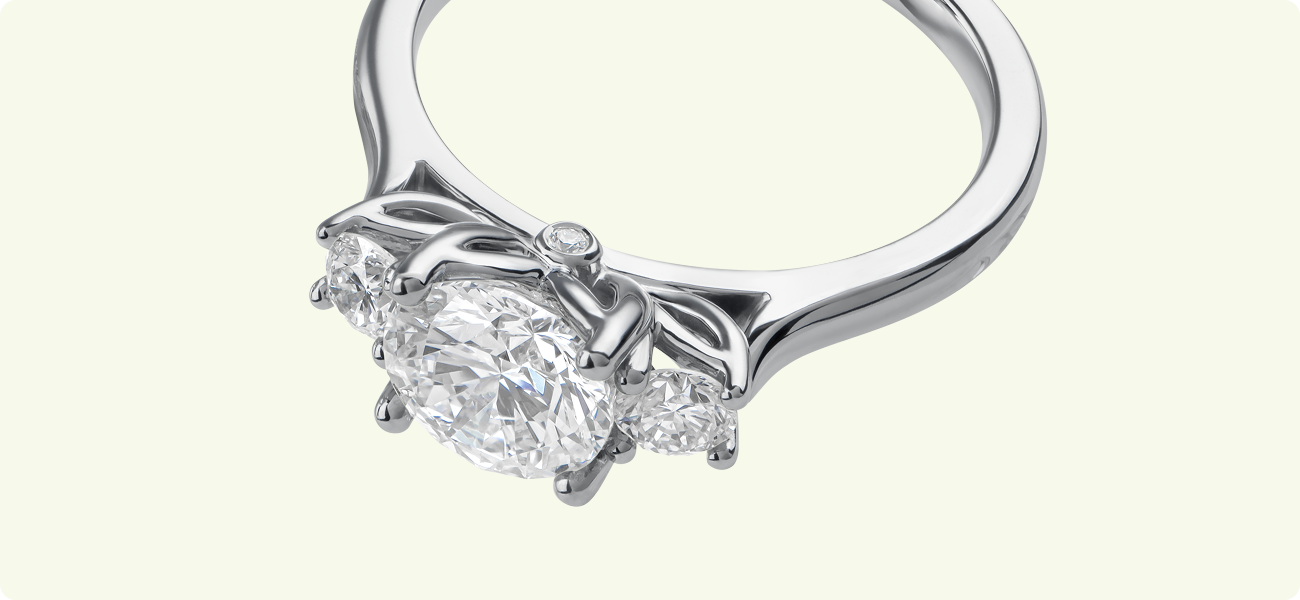 Close-up of petal prongs and hidden leaf gallery on a diamond trilogy ring.