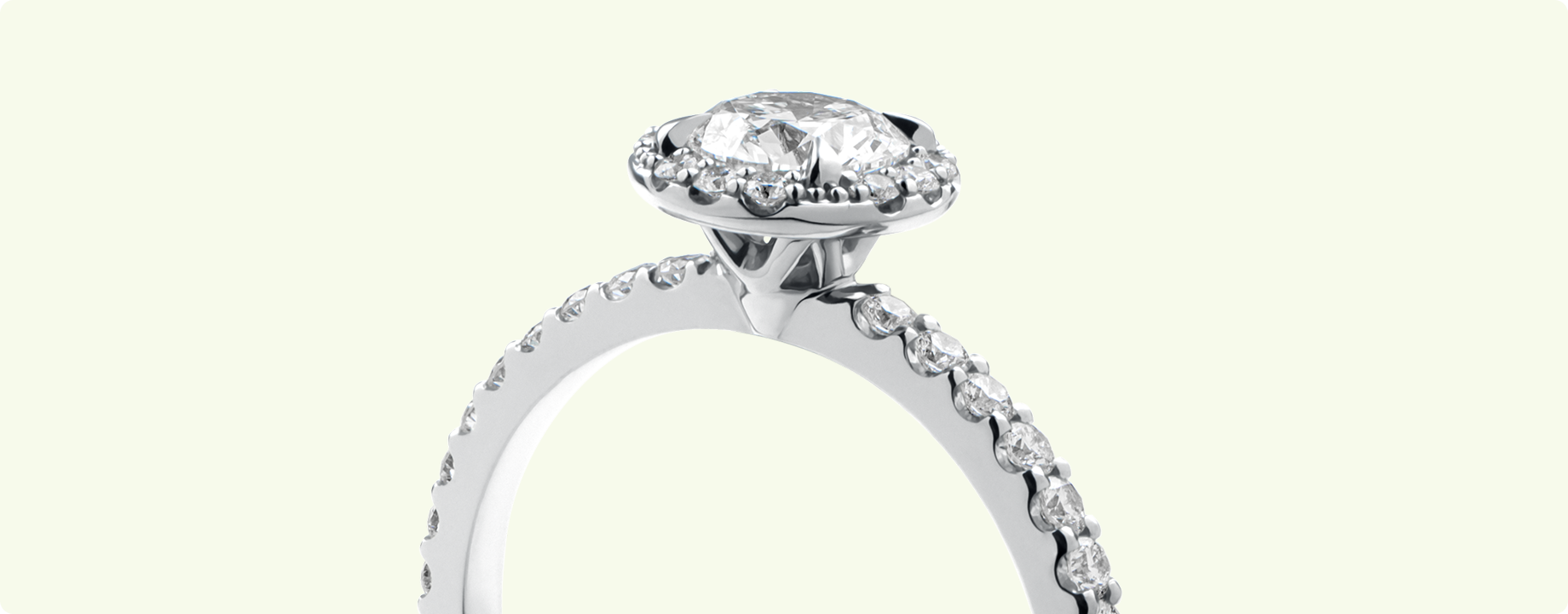 Side profile of a diamond halo engagement ring with a pavé band.
