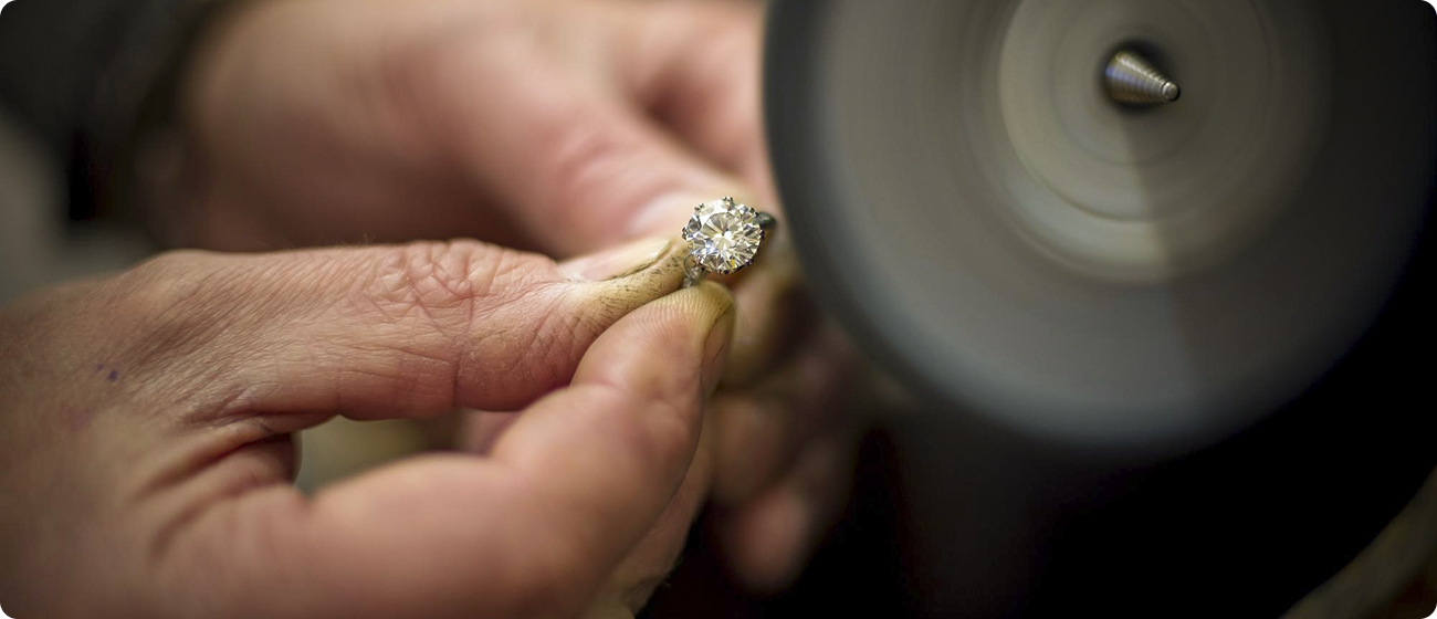 Artisans hand-crafting a diamond pavé band in our Montreal workshop.