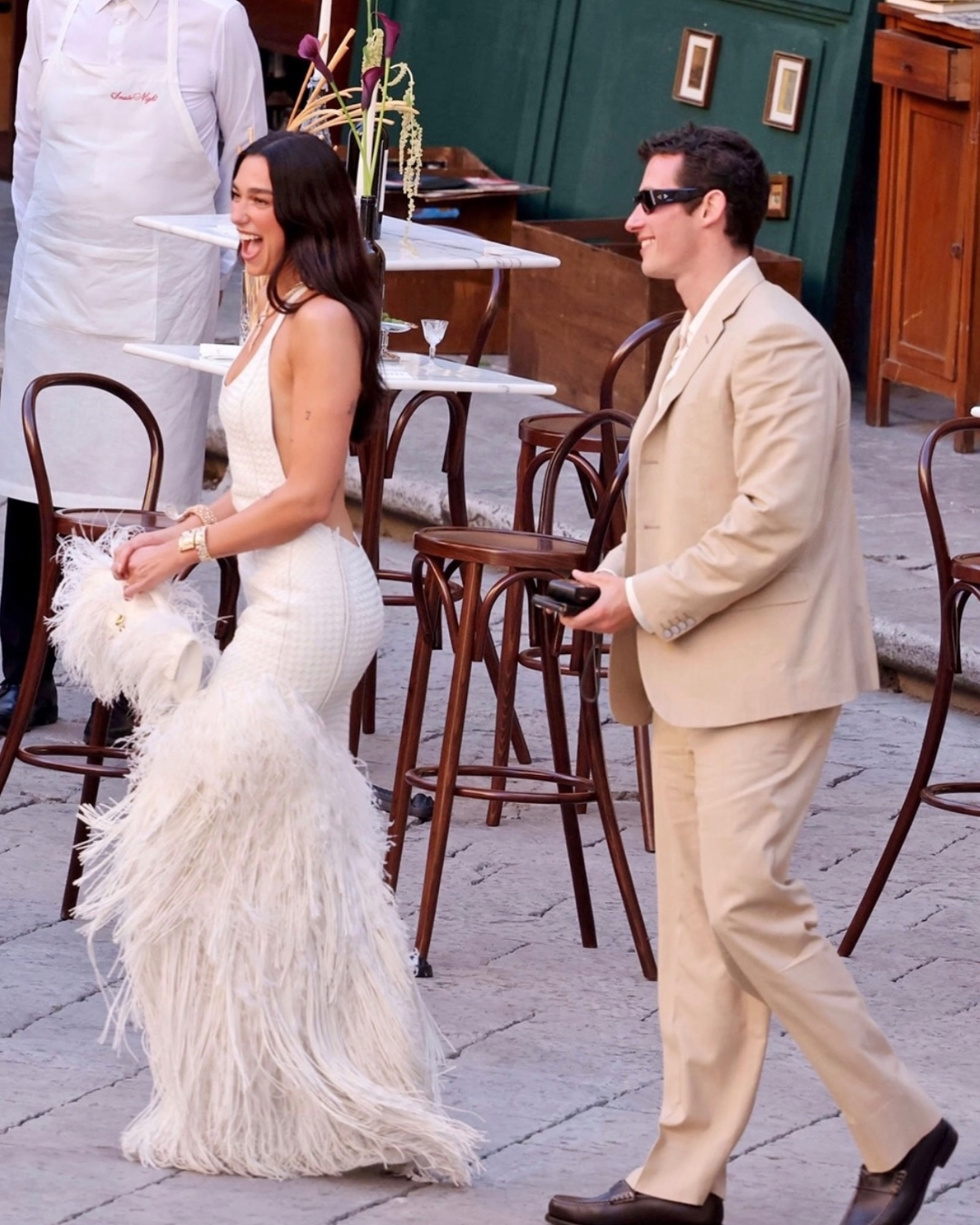 Dua Lipa en robe blanche portant deux montres et un collier Bvlgari