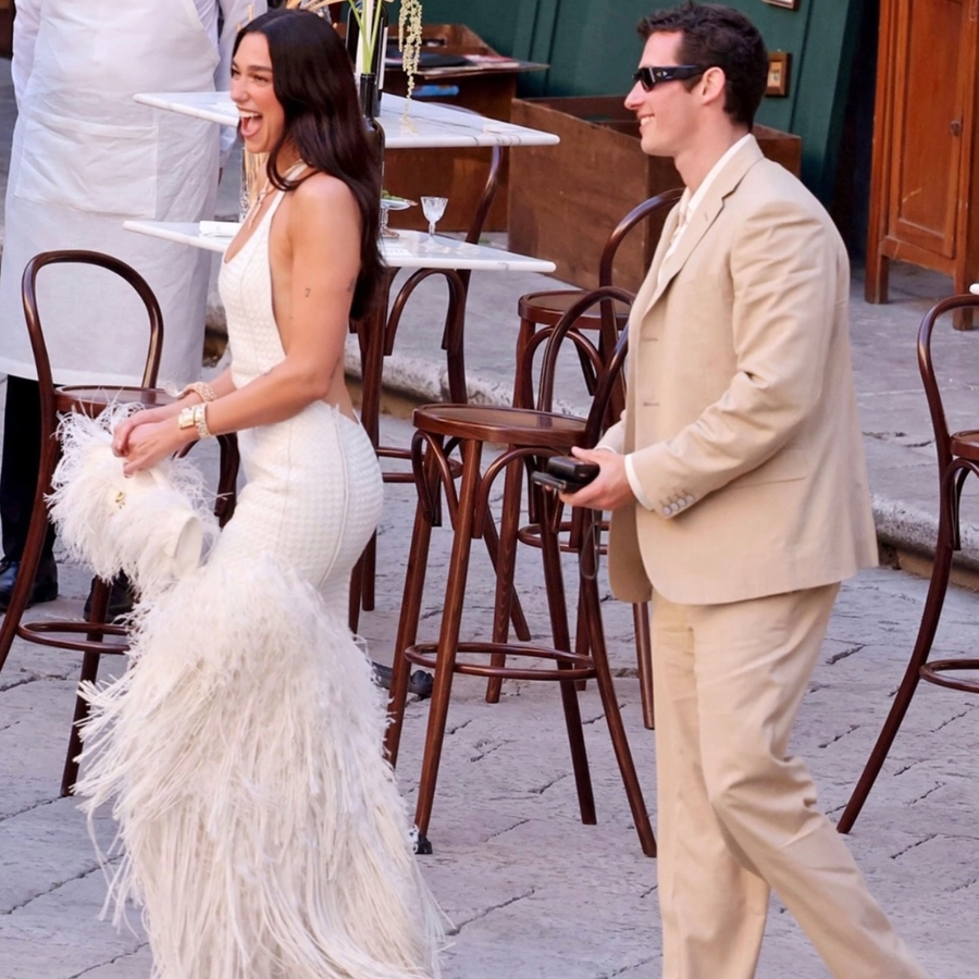 Dua Lipa en robe blanche portant deux montres et un collier Bvlgari