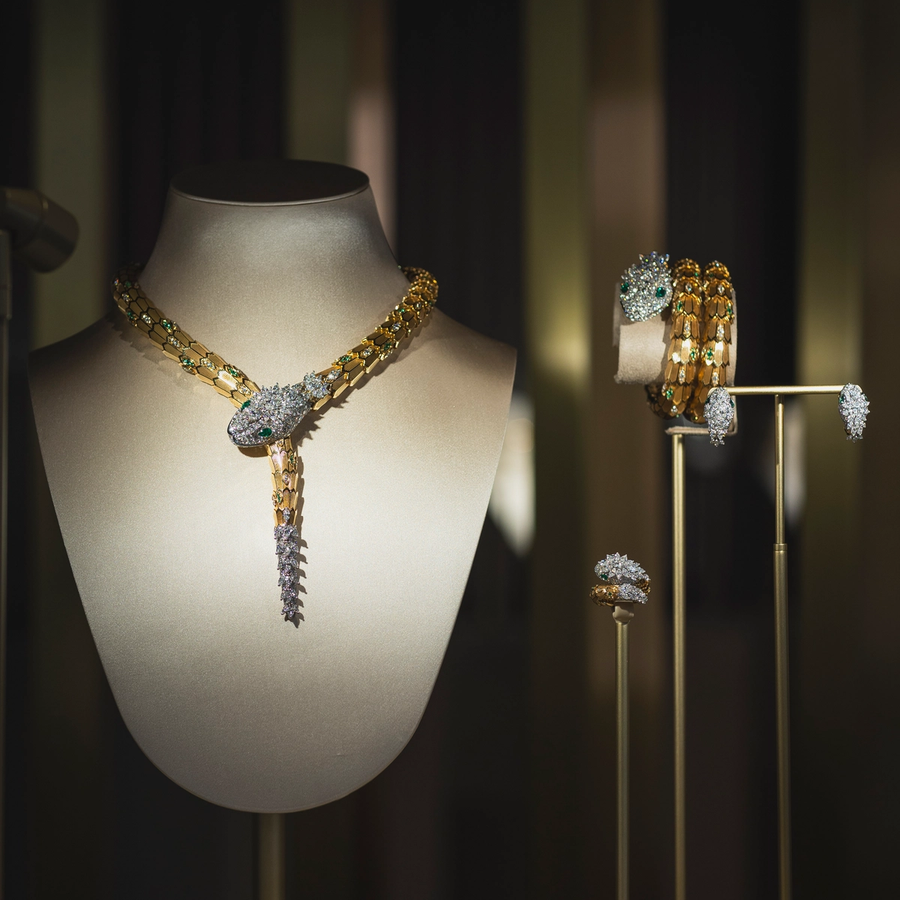 High jewelry display featuring dazzling Bulgari necklaces, rings, and bracelets, showcased on elegant busts under focused lighting.