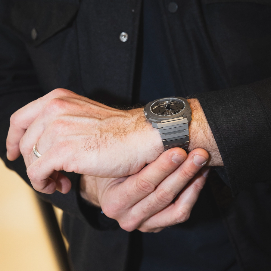 Close-up of a man adjusting a Bulgari Octo Finissimo watch on his wrist, showcasing the sleek and contemporary titanium design.