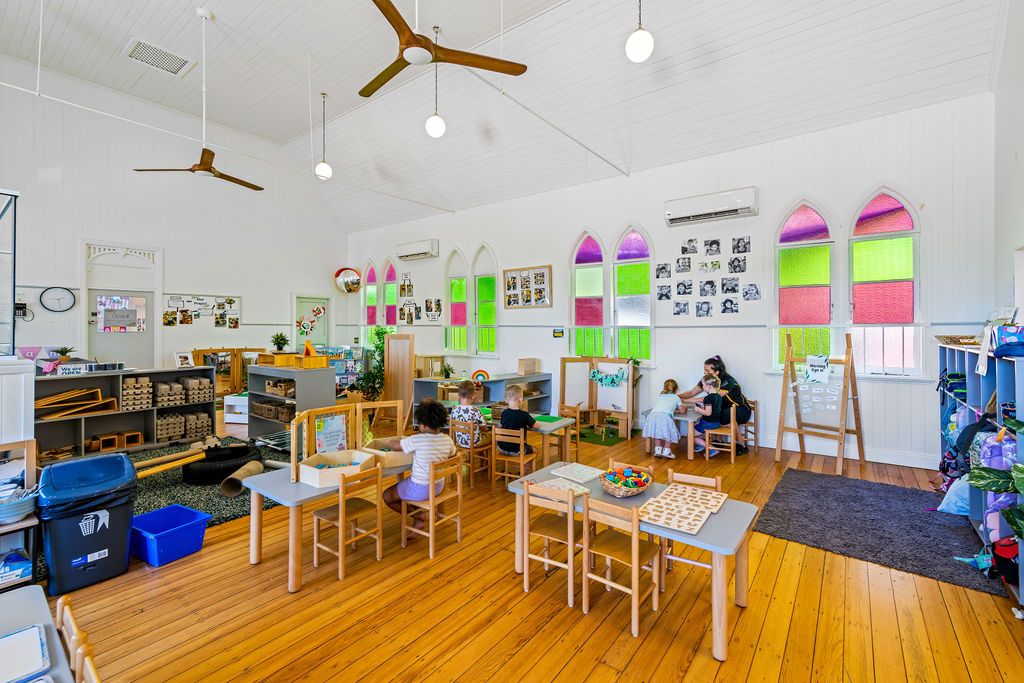 A large classroom with tables, toys and equipment
