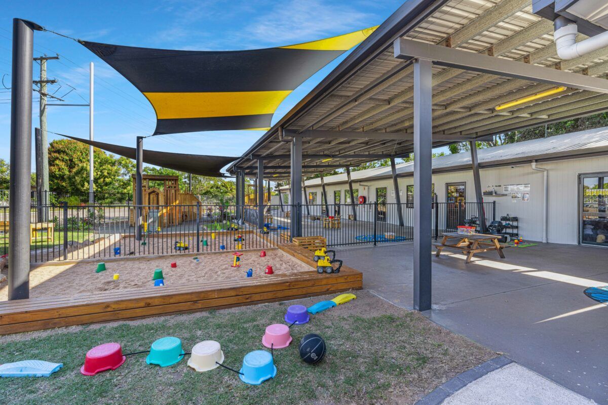 A large shaded playground with sandpits and toys