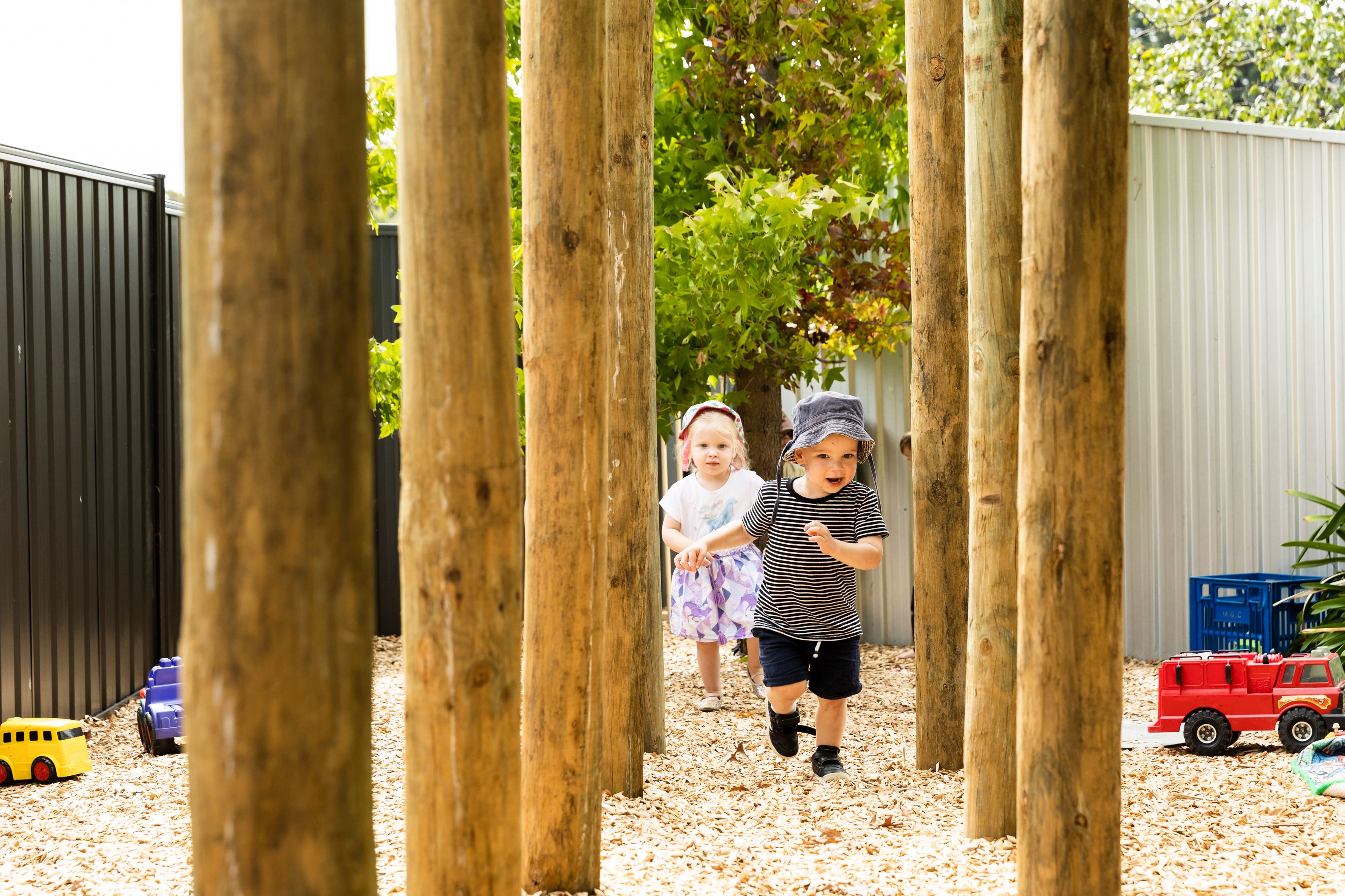 Two children running through a playground