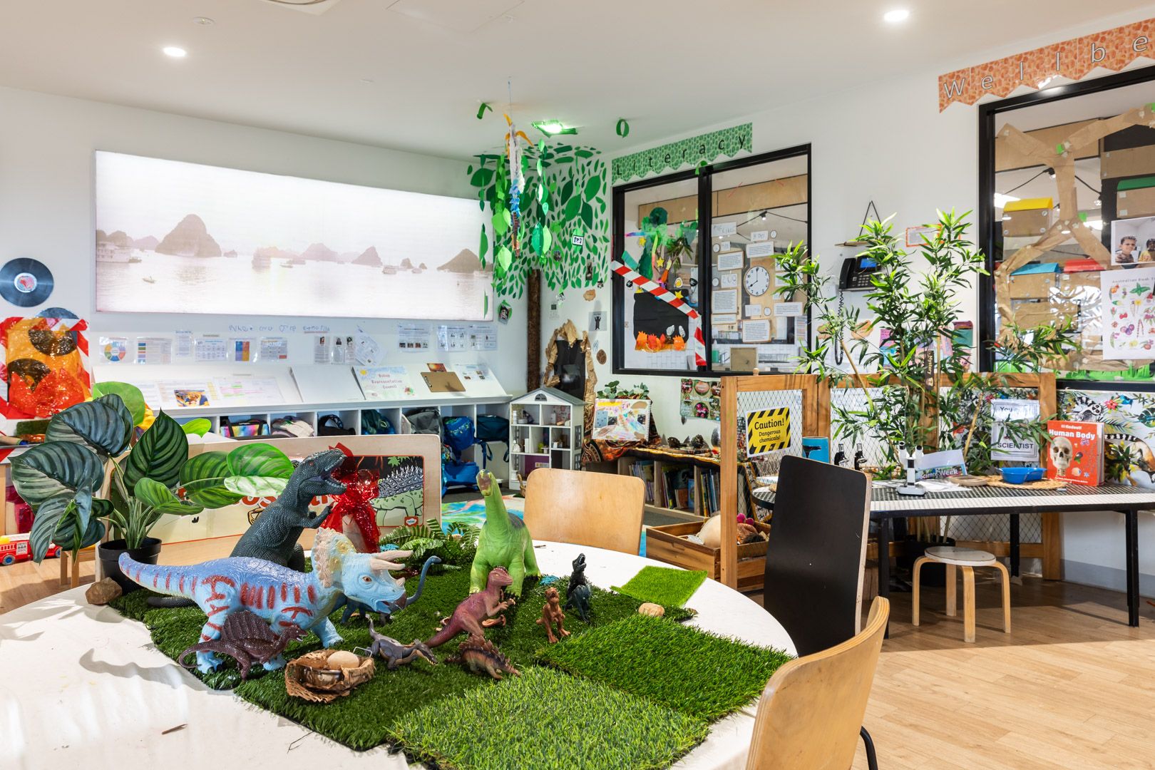 A bright classroom, with tables and play spaces