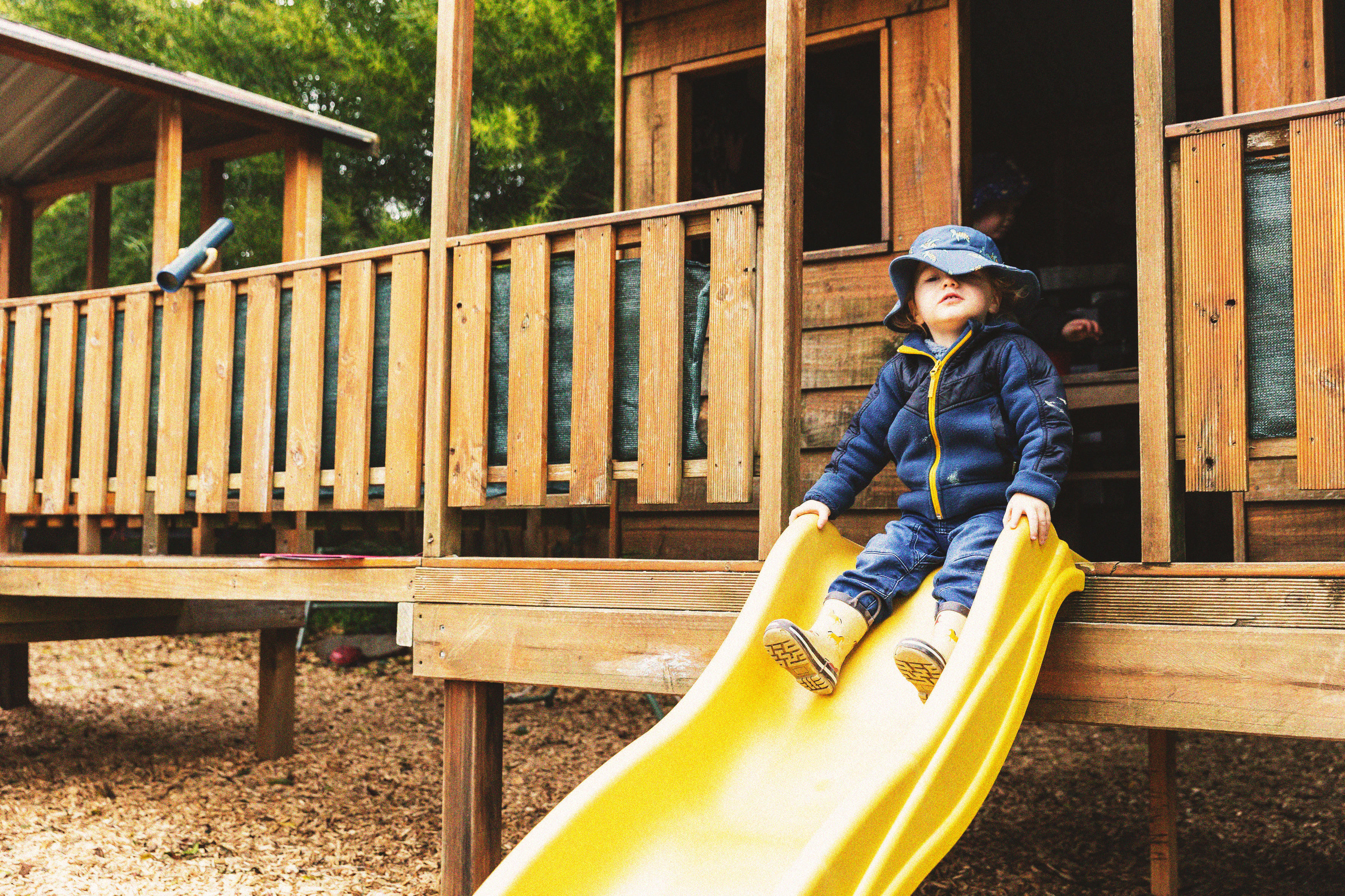 Young child going down a yellow slide