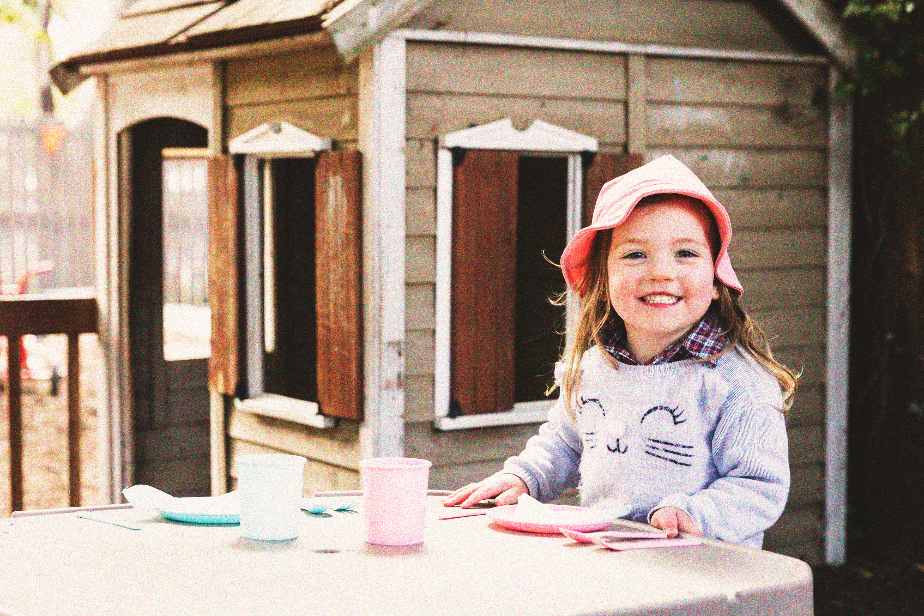 A young girl outdoors, smiling to camera