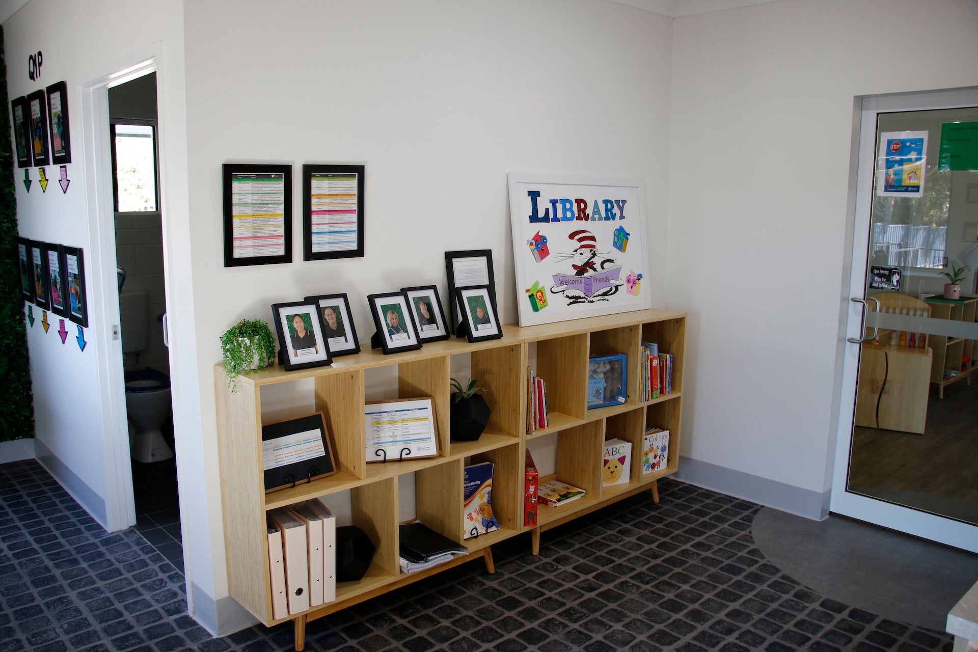 A bookshelf with pictures, certificates and books