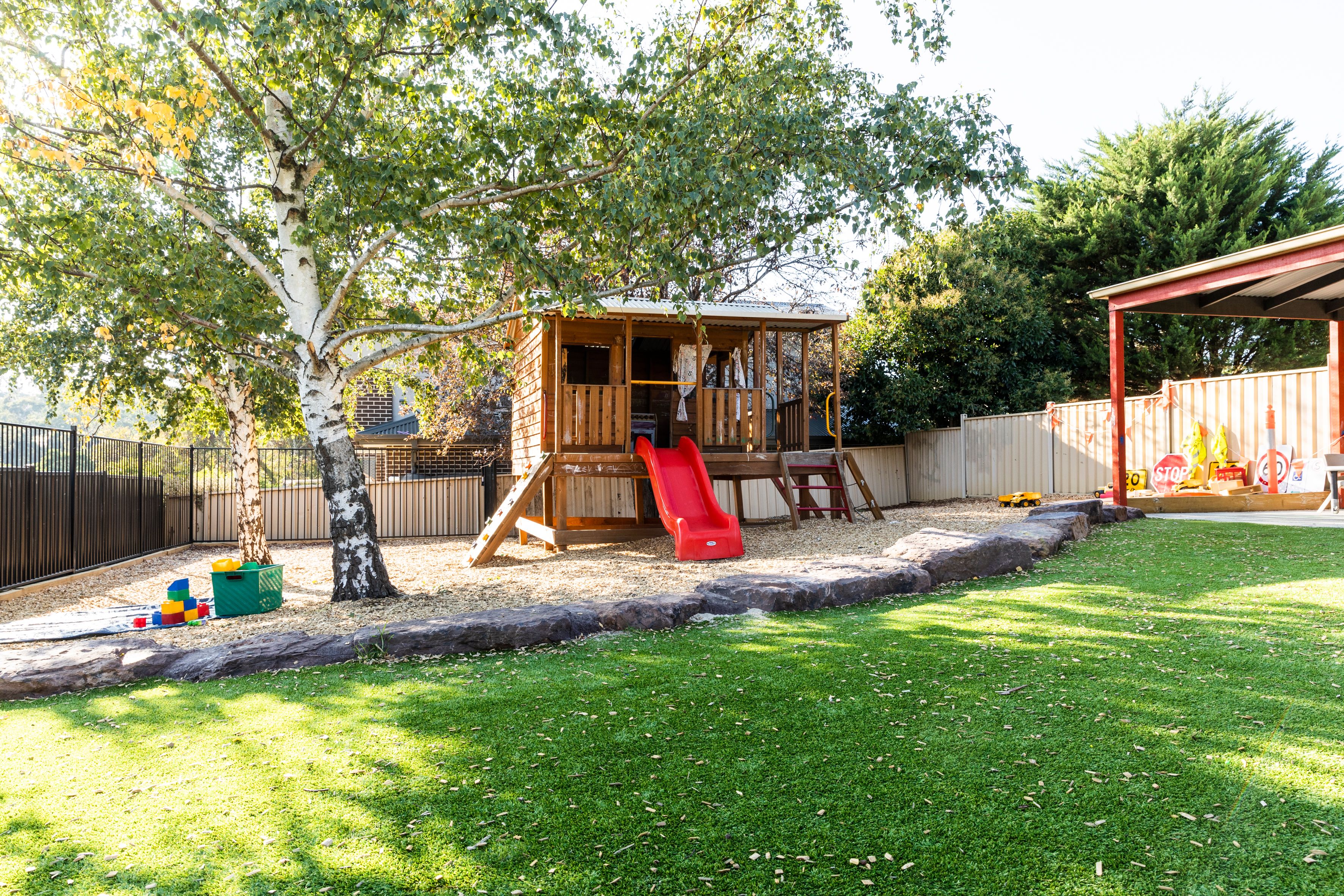 A large garden with grass, trees and a climbing