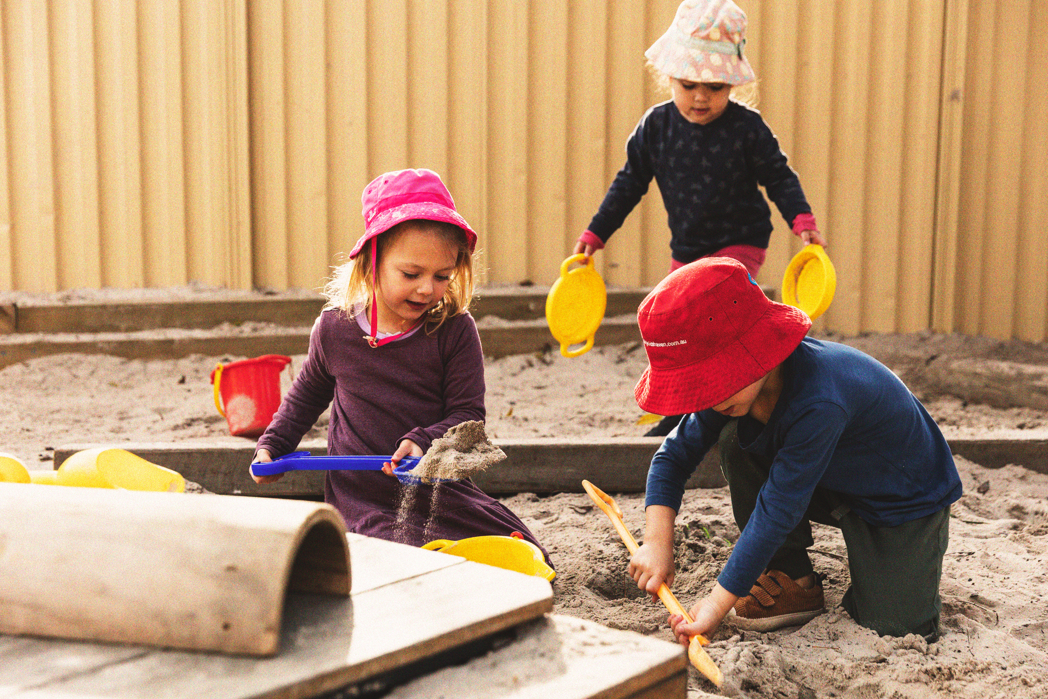 Young children playing in a sand pit