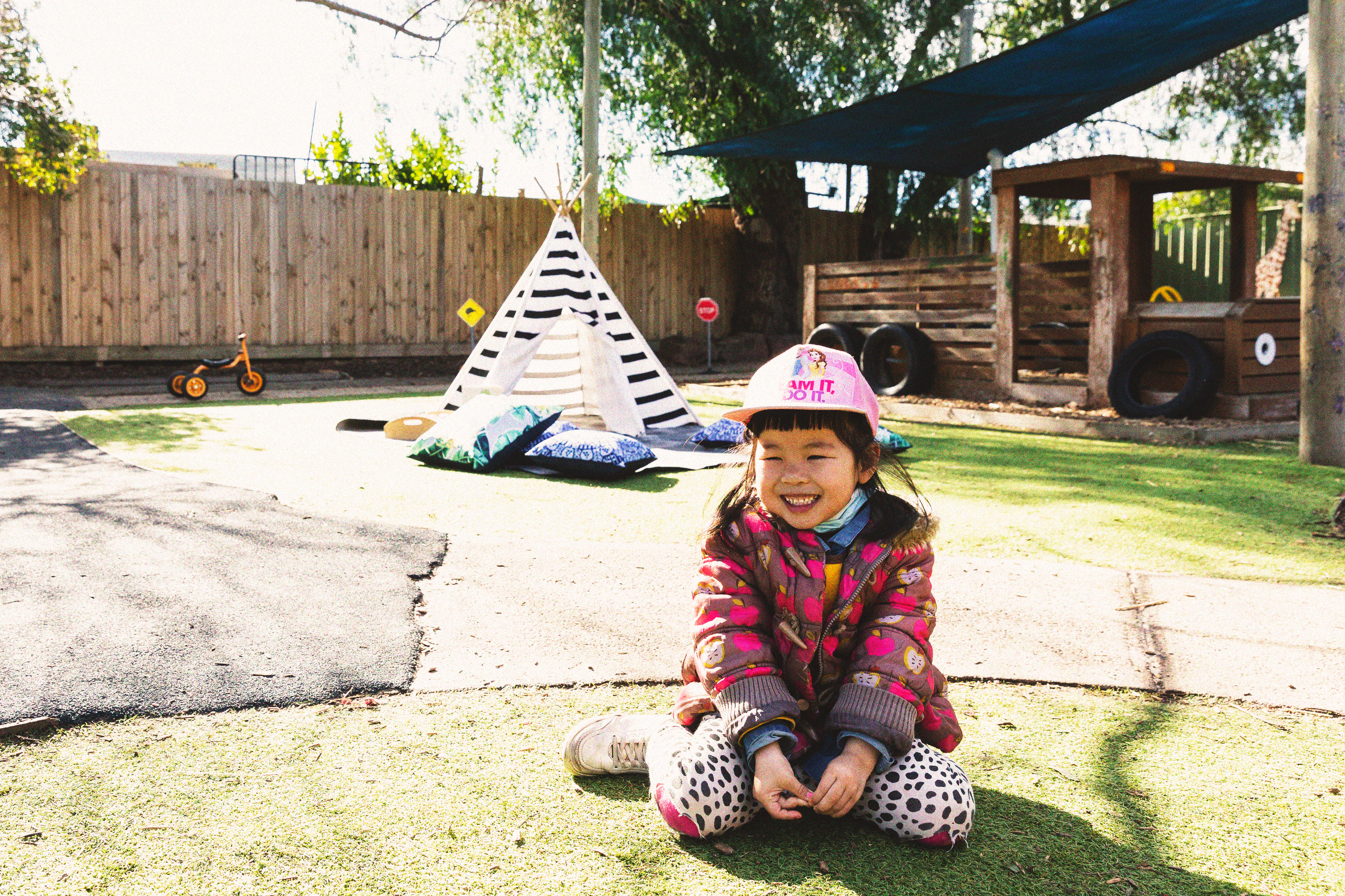 A young girl smiling in a playground