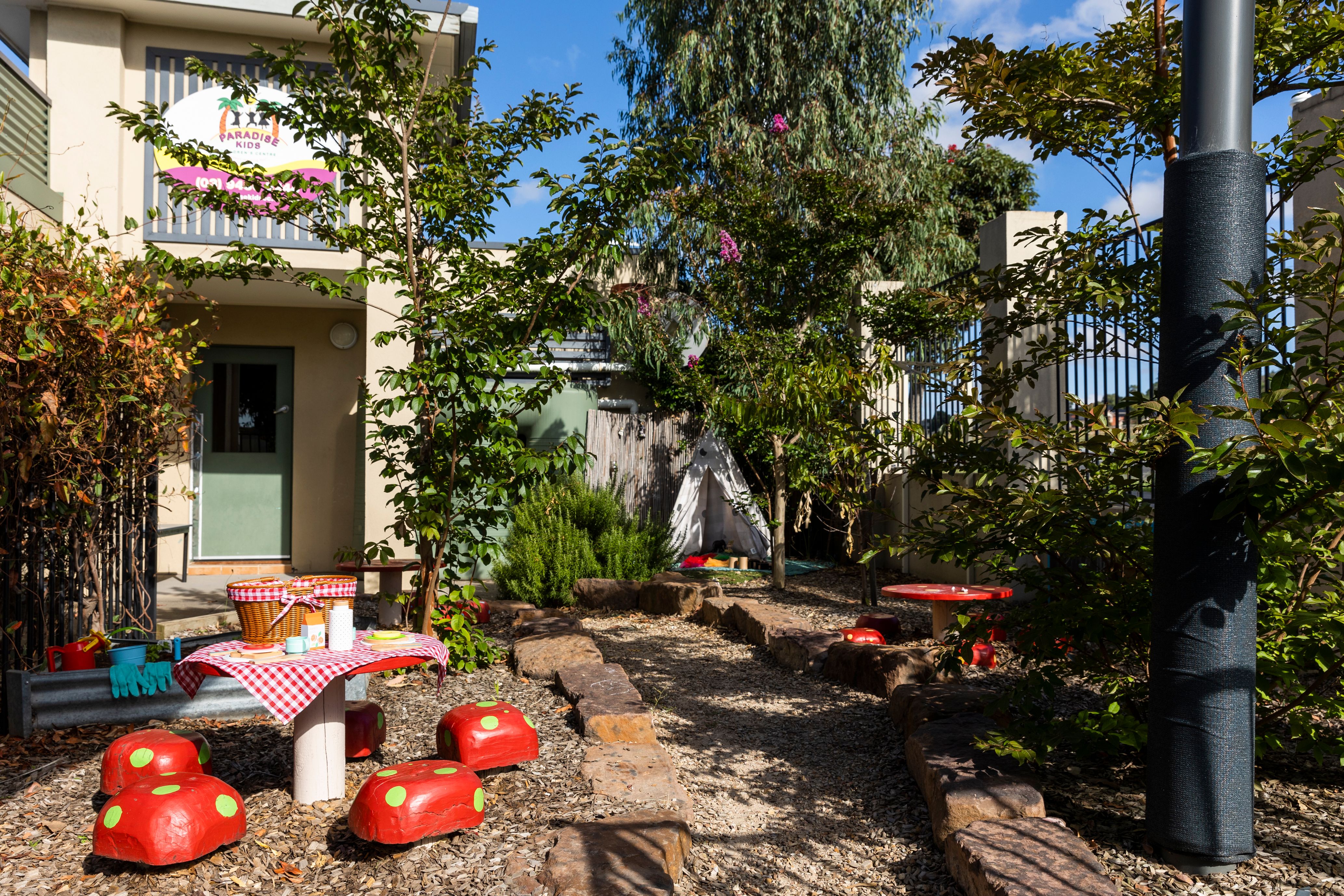 A leafy garden with picnic tables