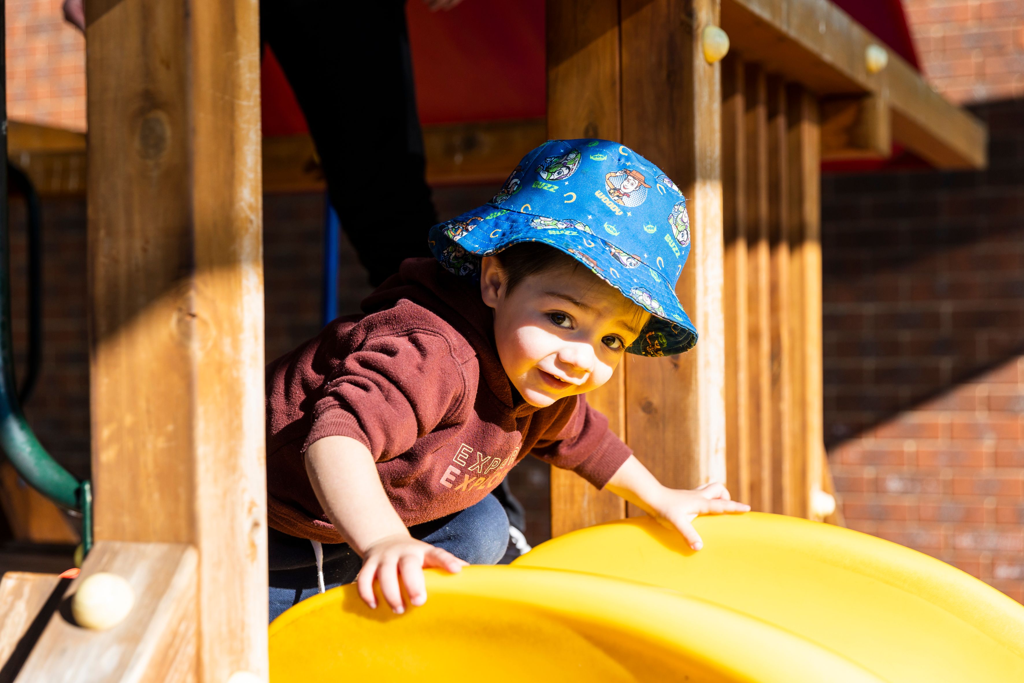 A young child approaching the top of a slide