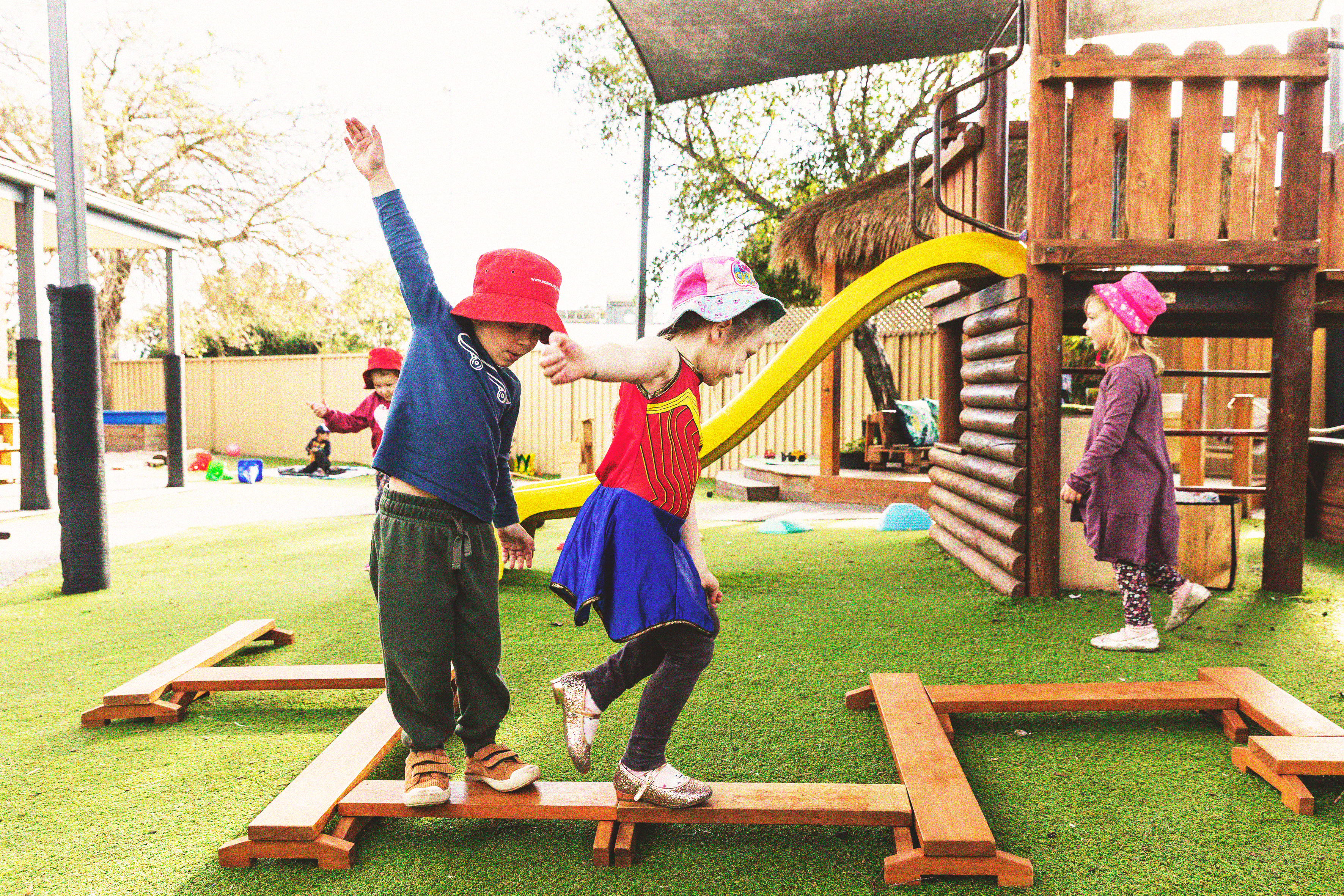 Some young children playing on balance beams