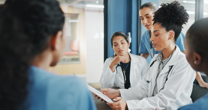 A multidisciplinary care team in a meeting room, reviewing a patient case together.