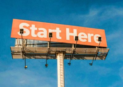 An image of large billboard showing the words: START HERE.
