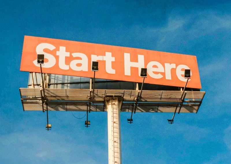 An image of large billboard showing the words: START HERE.