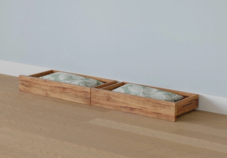 Two low wooden beds with light green leaf-patterned cushions on a wood floor against a blue wall.