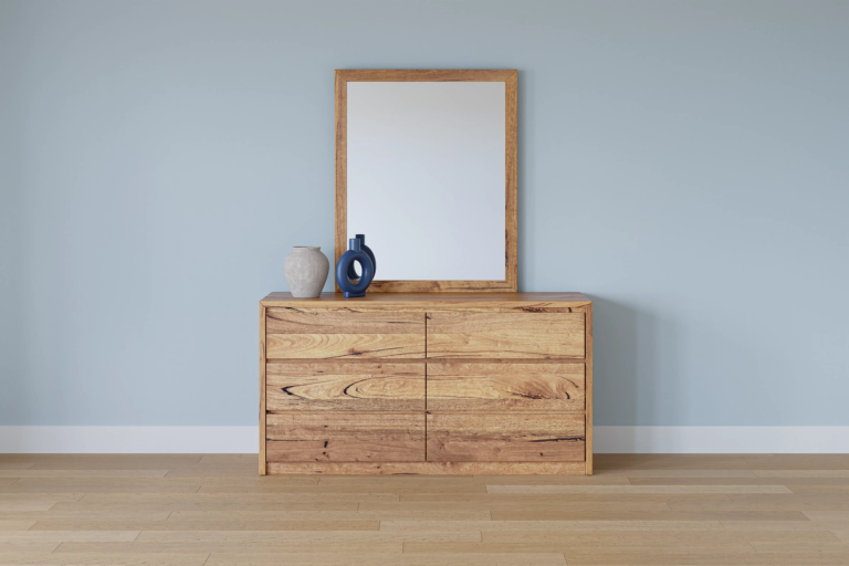 A wooden dresser with six drawers, topped by a matching wooden-framed mirror and two vases, against a light blue wall.
