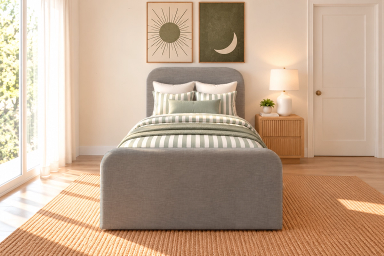 A bedroom with a grey upholstered bed, green and white striped bedding, a wooden nightstand with a lamp, and two framed sun and moon prints. A textured rug covers the floor.