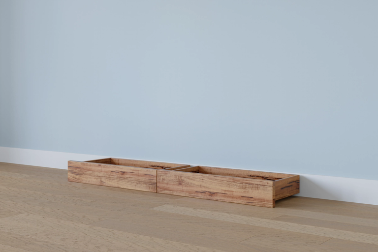 Two empty wooden planters on a wood floor against a light blue wall.