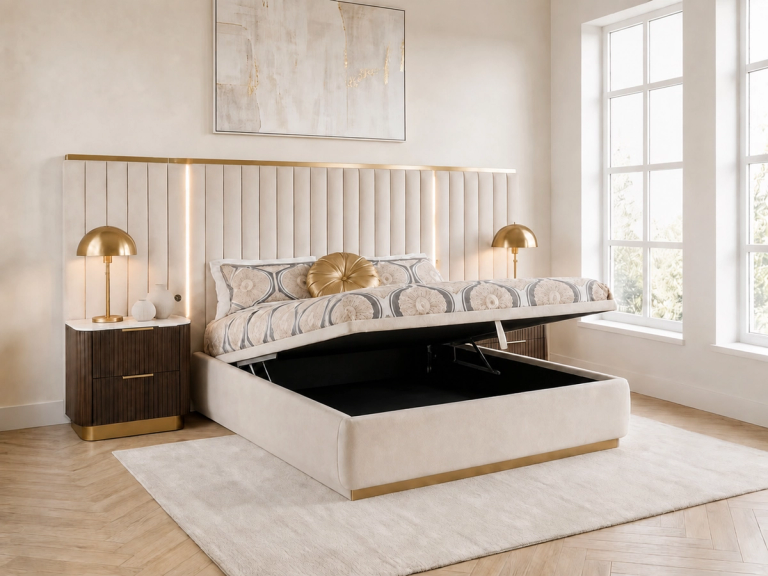 A cream upholstered ottoman bed is open, revealing storage, in a modern bedroom with a tall fluted headboard and gold accents.