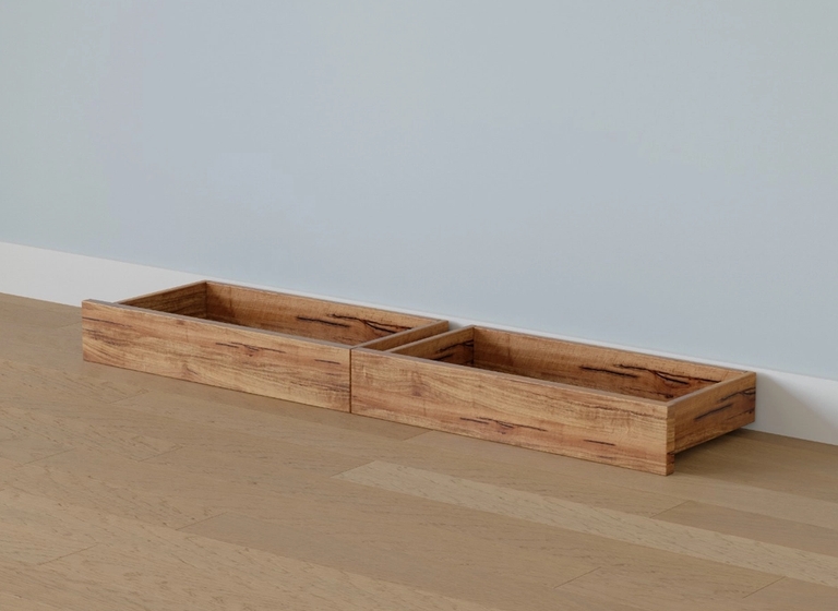 Two empty wooden boxes on a light wood floor against a pale blue wall.