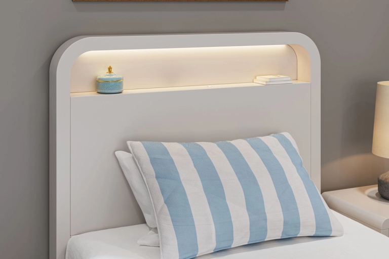 White headboard with an illuminated shelf above a blue and white striped pillow.