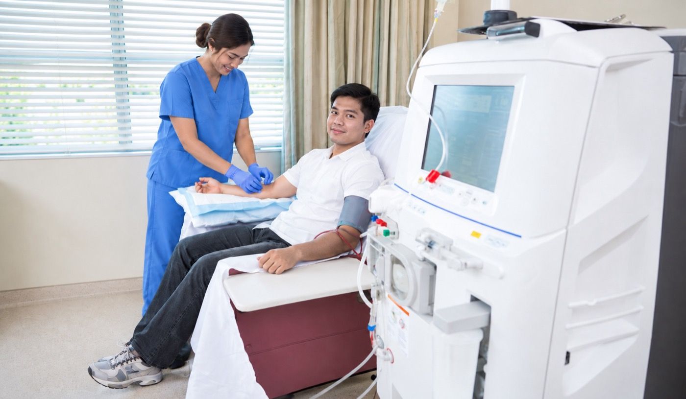 Nurse preparing a patient for hemodialysis treatment
