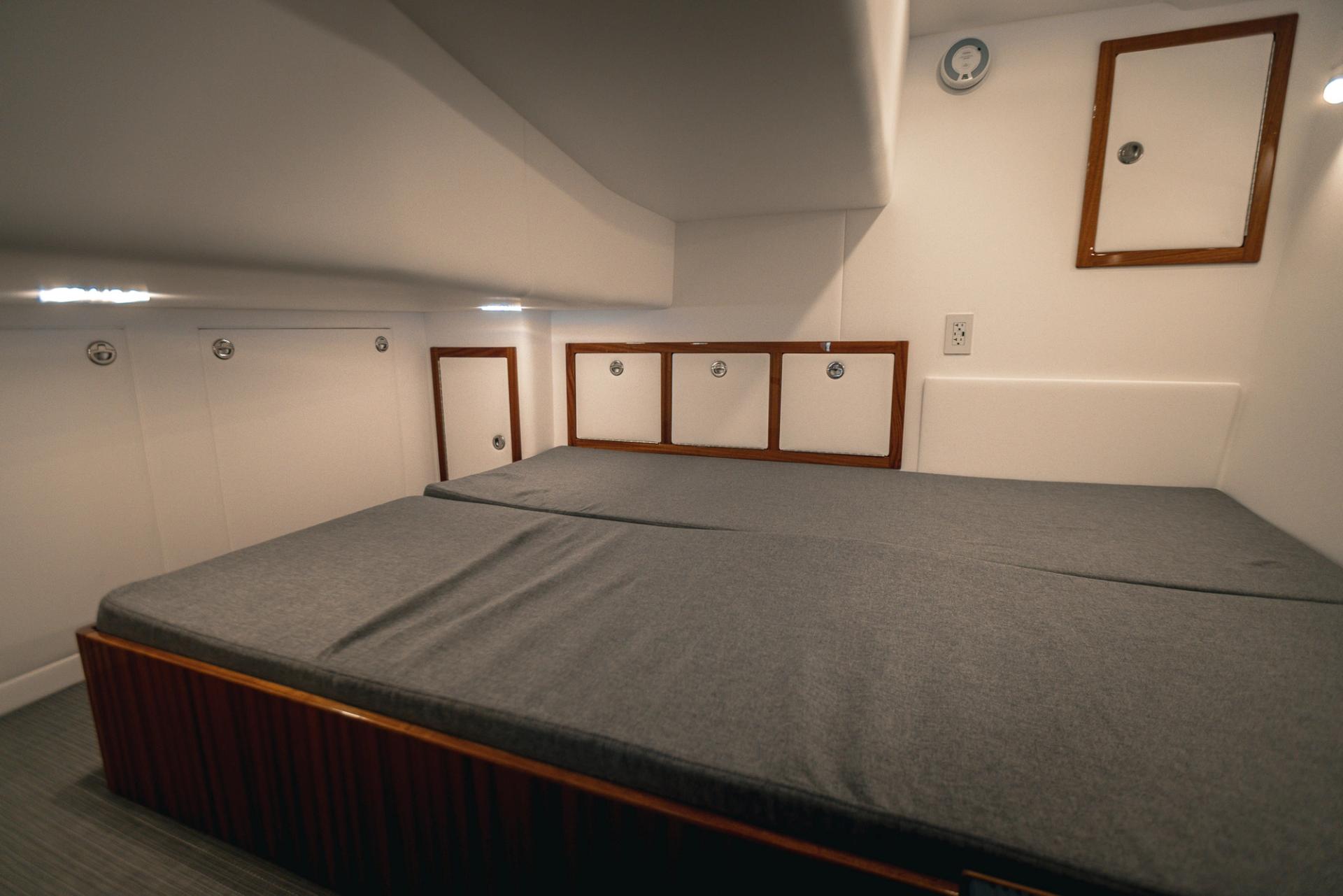 Aft Berth Queen Bed with lights on in Lindell 38