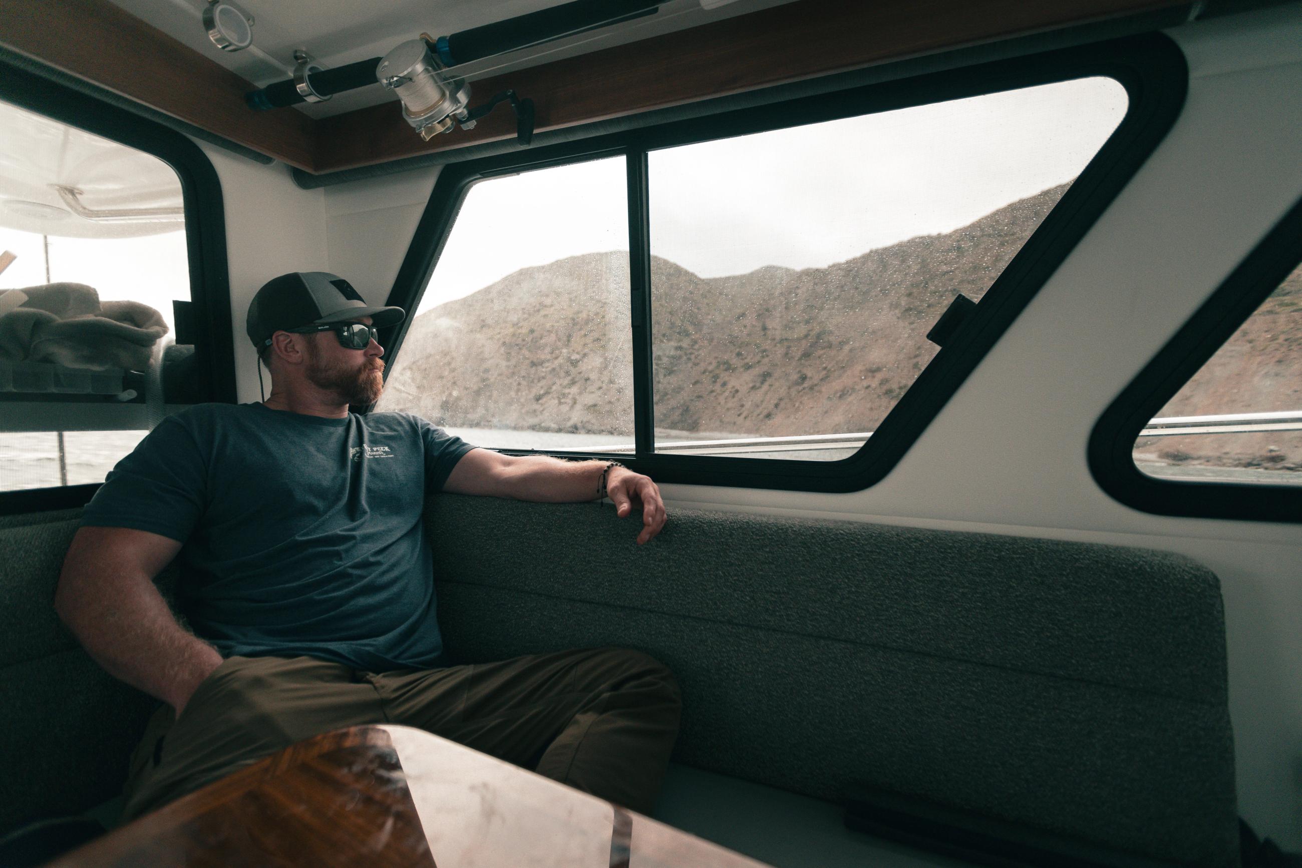 Fisherman looks out the port side window in the salon of the Lindell 41