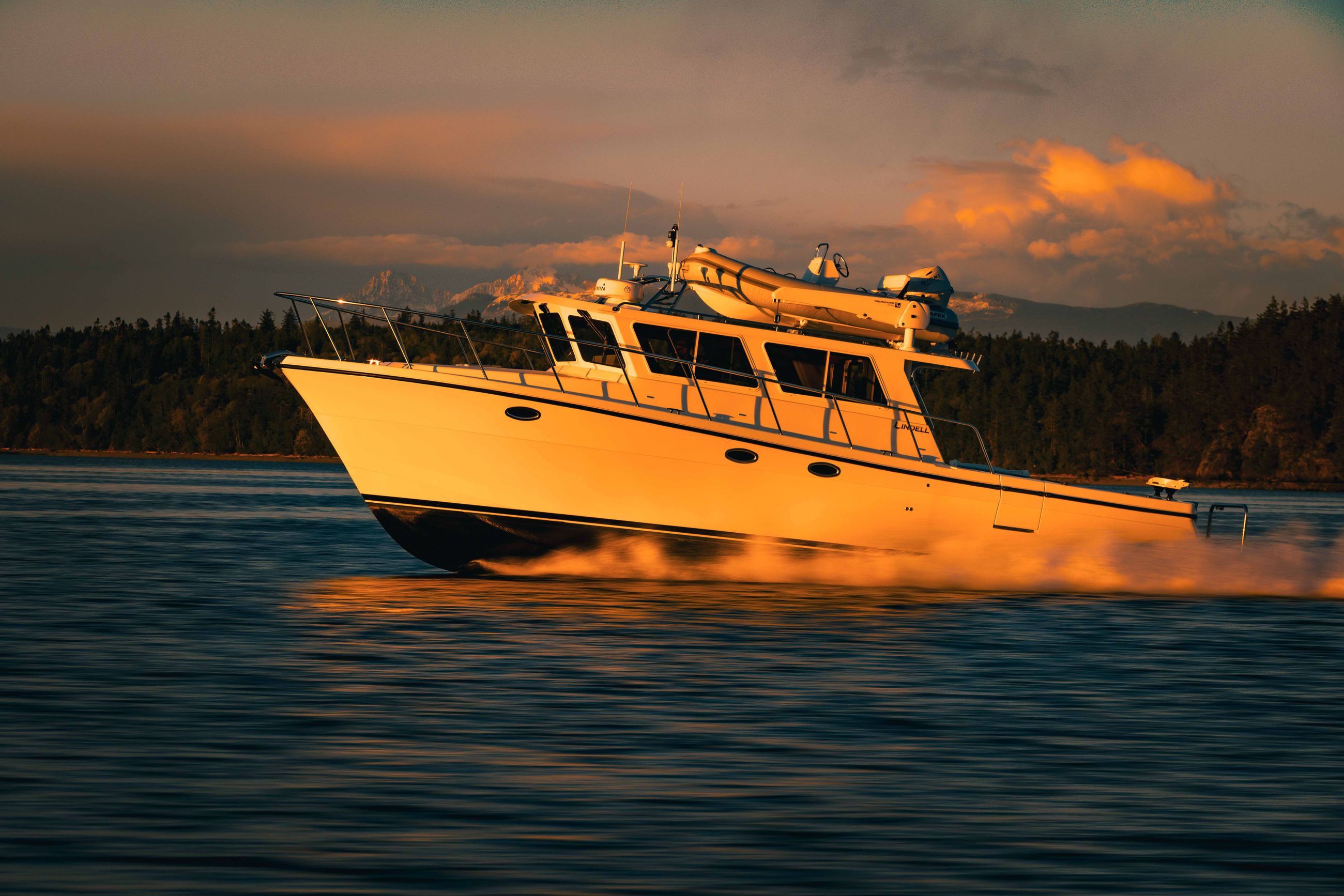 The Lindell 42' glowing in the sun with the mountains near La Conner Washington behind it