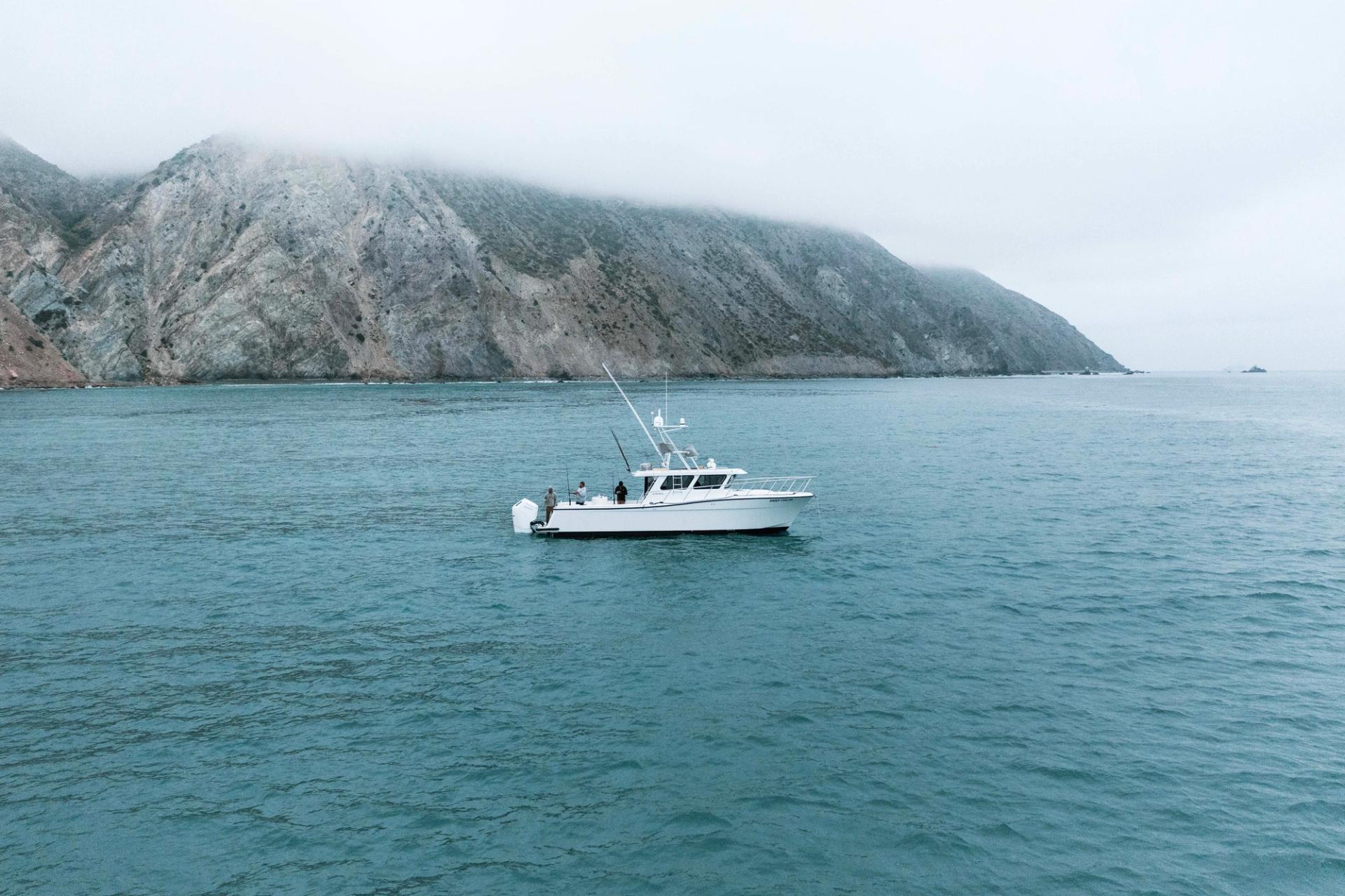 Lindell 41 fishing, viewed from starboard side near Pacific Ocean California cliffs