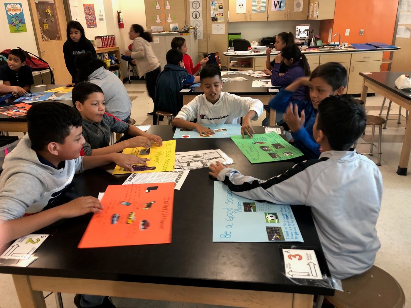 Sugar Grove Academy students at their classroom tables, sharing the posters they made