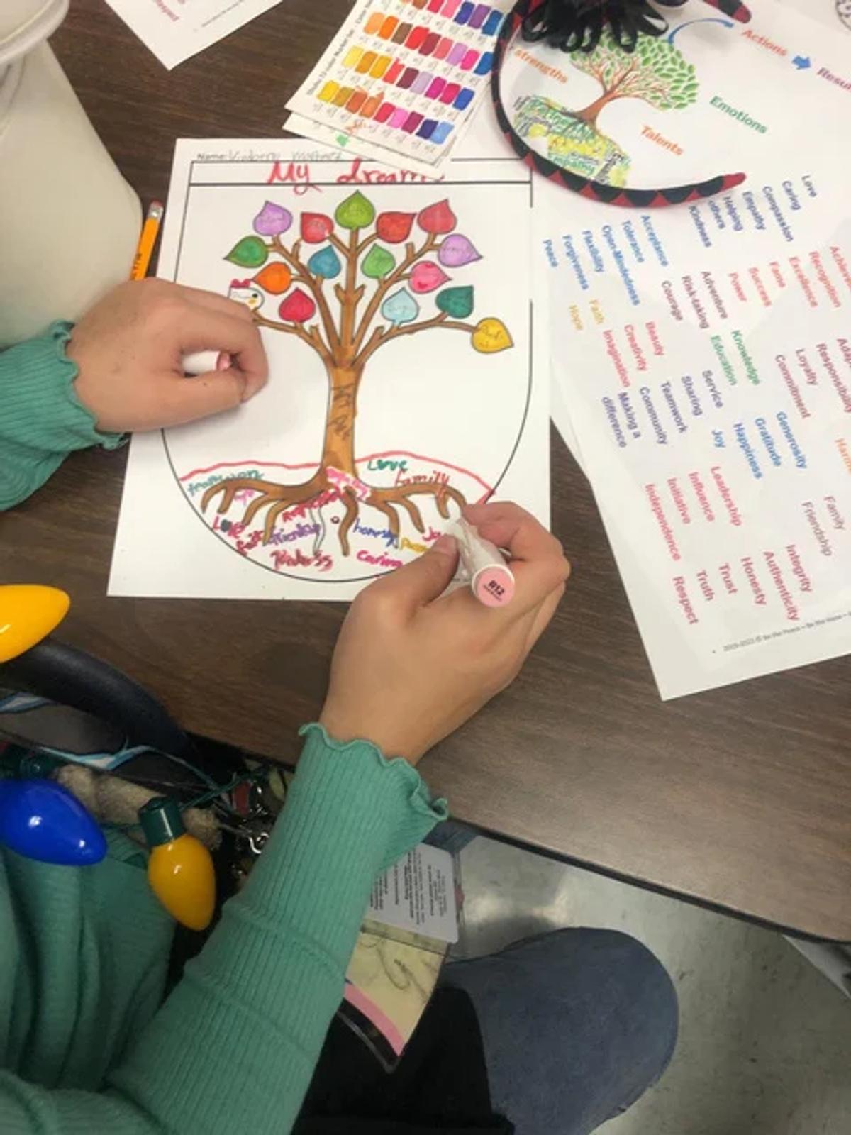 A student coloring her personal Tree Crest