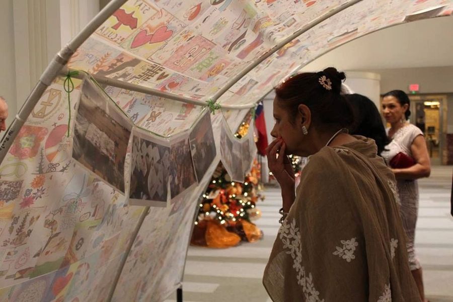 A visitor looking at the hope tent covered in children’s art