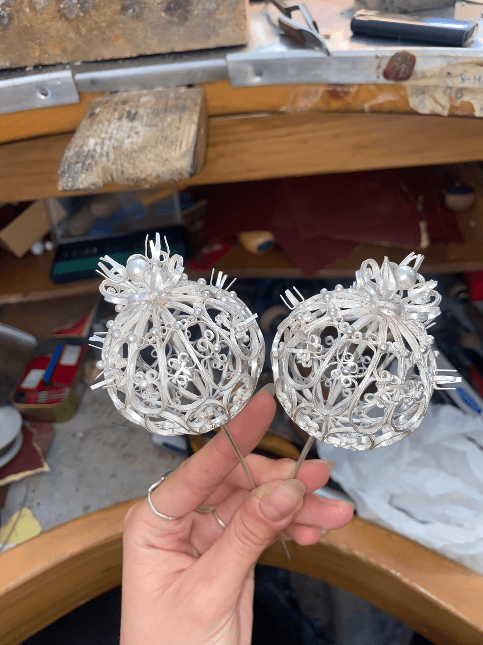 Noemi holding two filigree metalwork