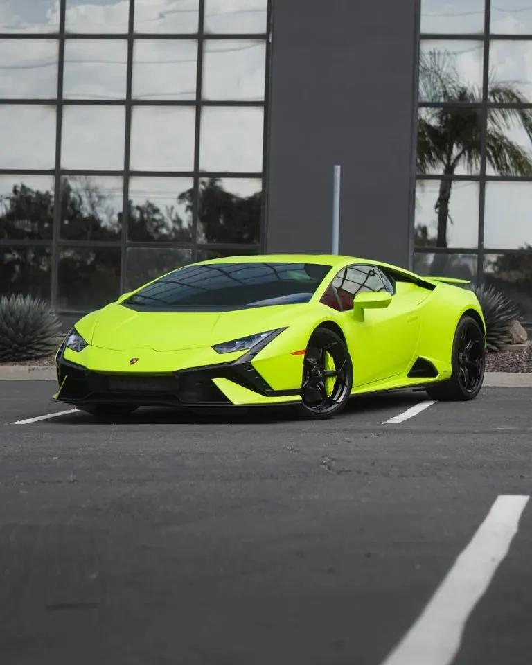 Neon green Lamborghini parked at a modern building