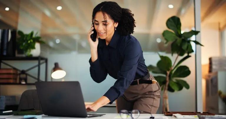 Woman working on a laptop at night on a phone call