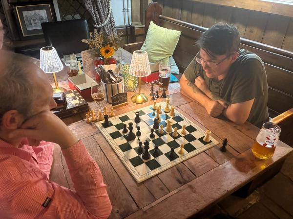 Club members playing chess at a table in The Swan Inn