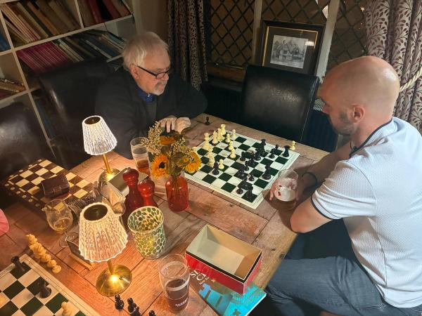 Club members playing chess at a table in The Swan Inn
