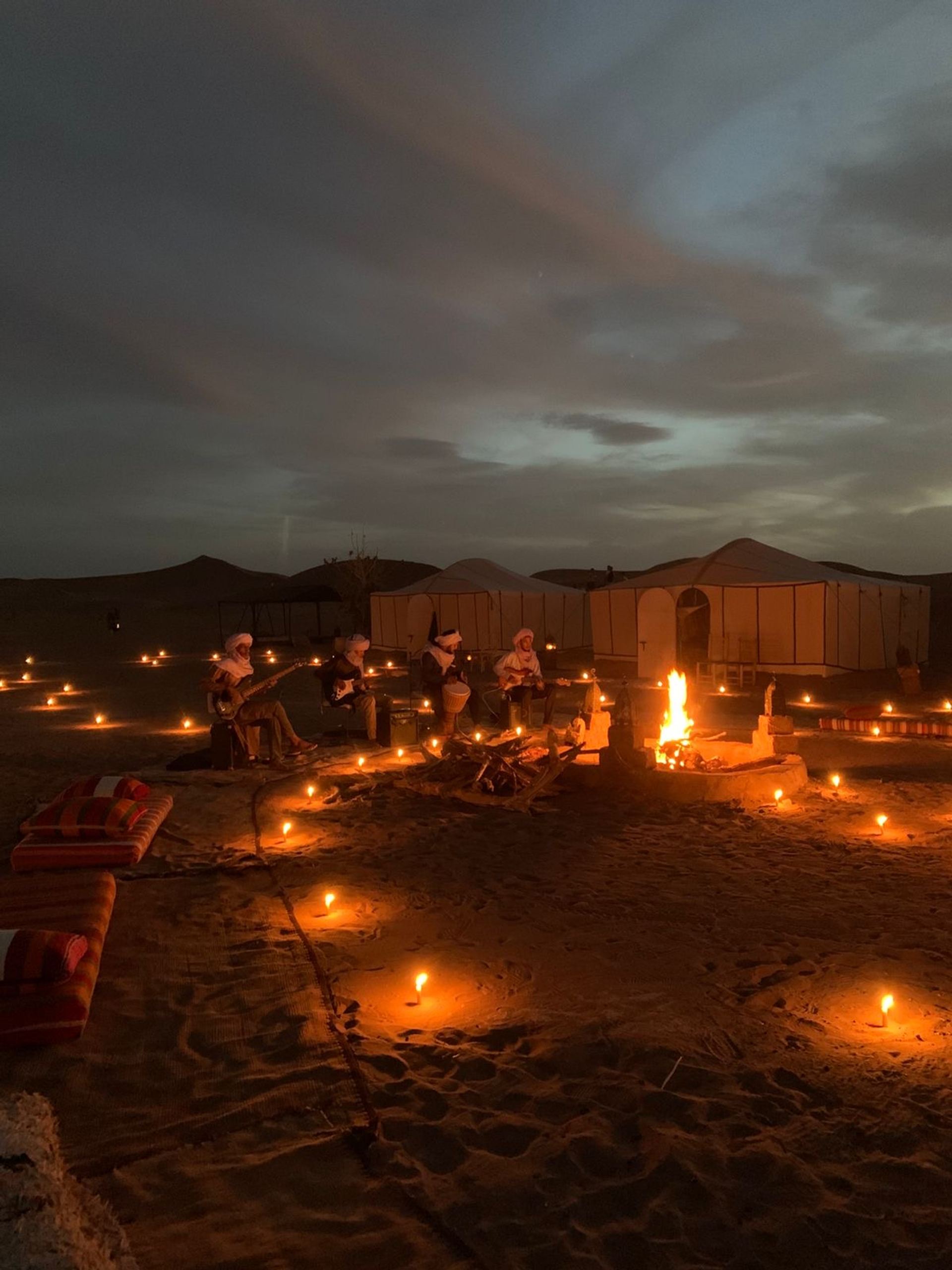 Familie auf der Düne über dem Wüstencamp bei Sonnenuntergang