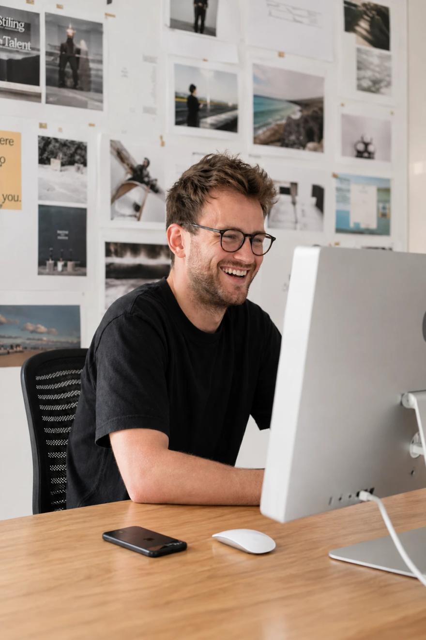 A PPC specialist smiling at their desk while working on a campaign