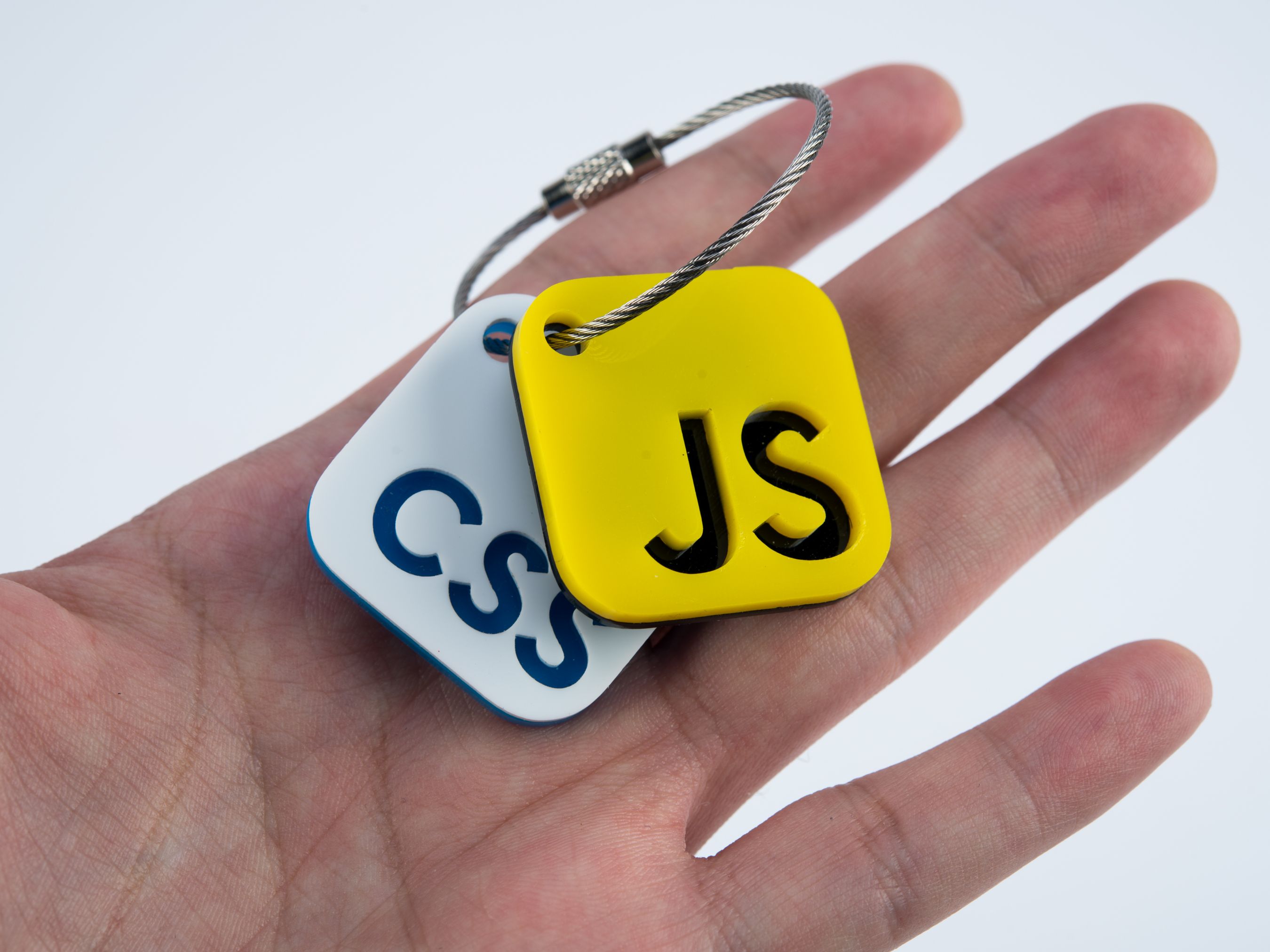 CSS and JavaScript Keychains on someone's hand