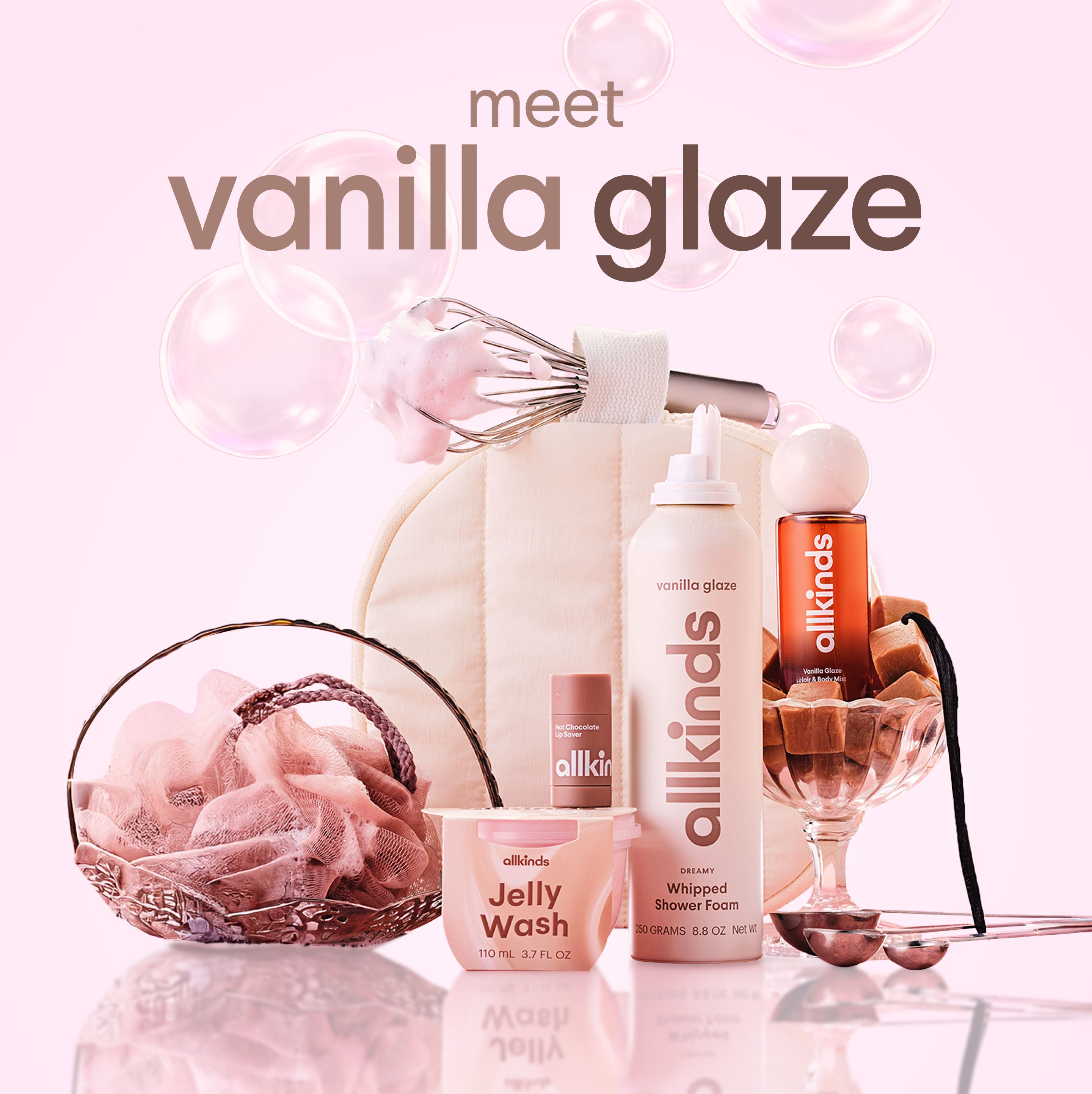 Allkinds 'Vanilla Glaze' bath products, including whipped shower foam and jelly wash, are displayed with a whisk, loofah, caramels, and pink bubbles on a pink background. Text: 'meet vanilla glaze'.
