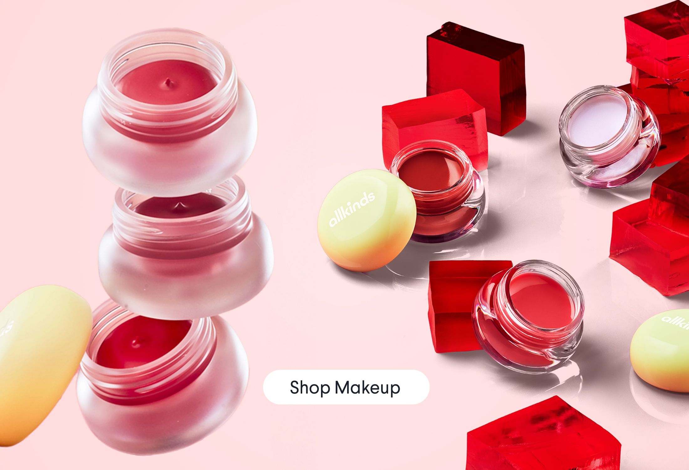 a variety of lip balms are stacked on top of each other on a pink surface .