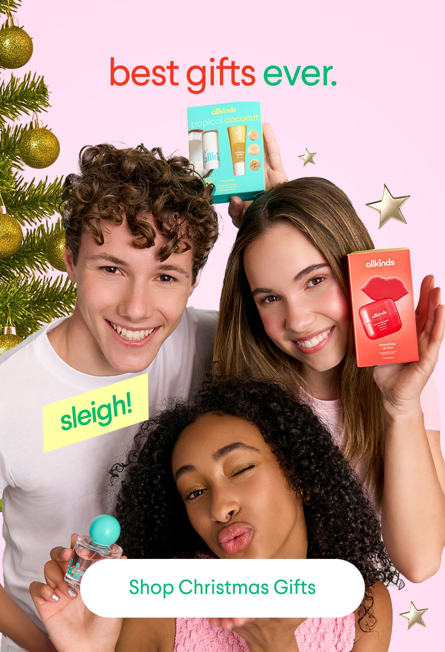 Three smiling young people present Allkinds beauty products amidst Christmas decorations, with text reading "best gifts ever." and "Shop Christmas Gifts."
