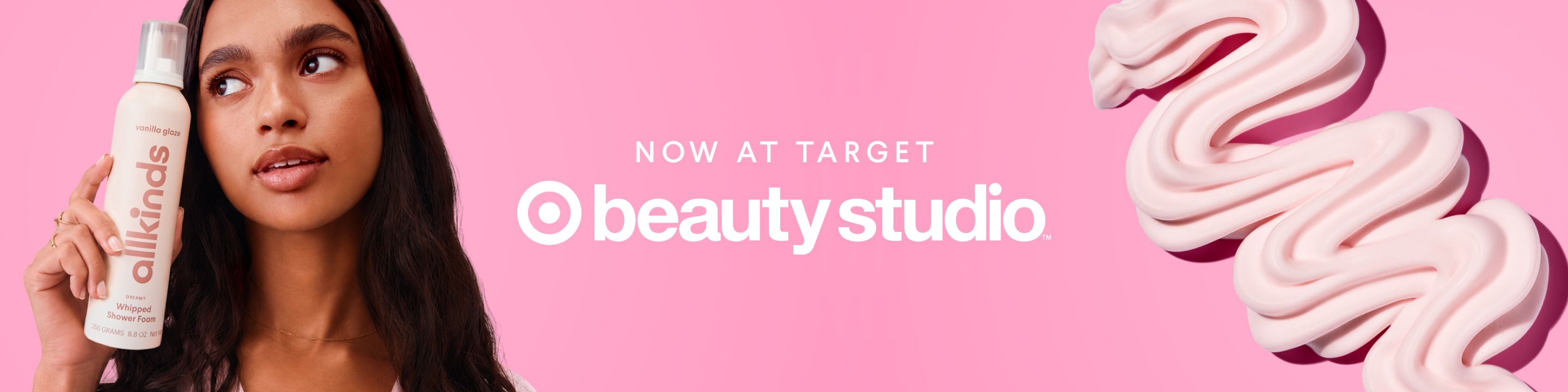 A woman holds an allkinds product bottle next to text "NOW AT TARGET beauty studio," with pink product swirls on a pink background.